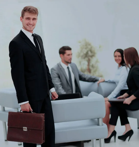 Успішний бізнесмен стоїть зі своїм персоналом на задньому плані — стокове фото
