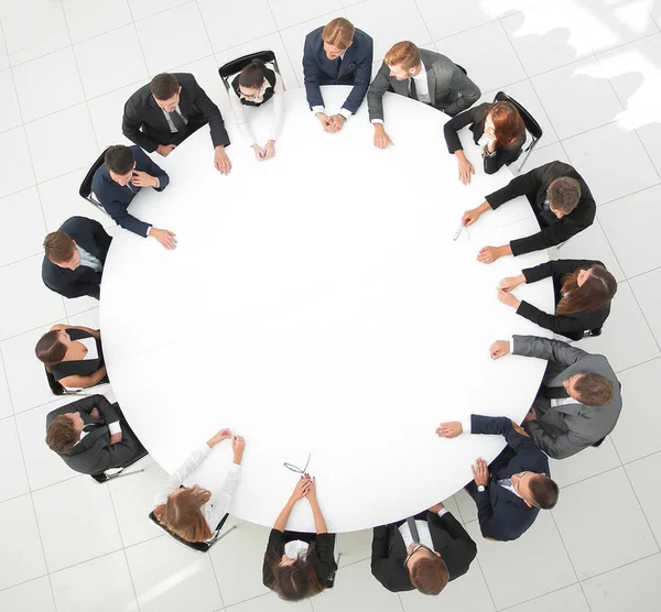 Eine große Gruppe von Geschäftsleuten sitzt am runden Tisch. das Geschäftskonzept. — Stockfoto