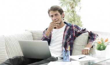 şaşırmış genç adam evden dizüstü bilgisayar ile çalışma.