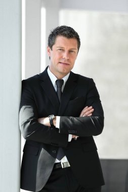 office penceresinde yakınındaki ayakta ciddi iş adamı.