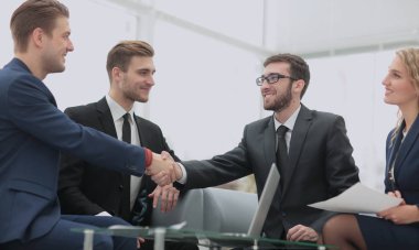 Modern bir ofiste iş adamları arasında el sıkışma