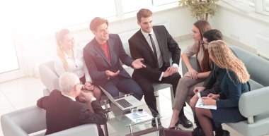 bir dizüstü bilgisayar ve iş ekibi ile gülümseyen olgun Yöneticisi