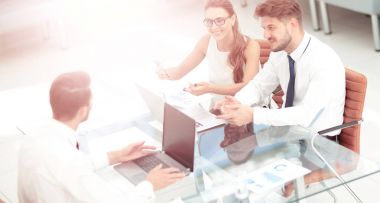 Modern ofiste masanın etrafında çalışan iş adamları.