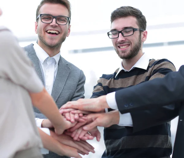 Equipo de negocios de pie uniendo sus manos — Foto de Stock