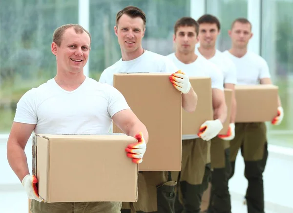 Equipe de construtores com caixas de materiais de construção — Fotografia de Stock