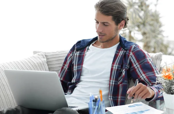Selbstbewusster Typ, der von zu Hause aus mit Laptop arbeitet. Konzept der Freiberuflichkeit — Stockfoto