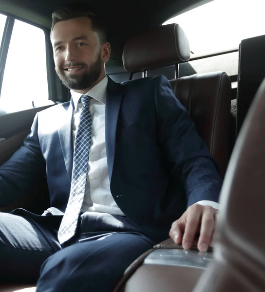 businessman sitting in the back seat of a car
