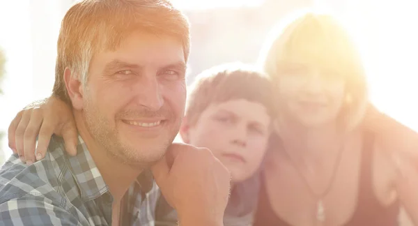 Familie mit zwei Kindern sitzt zusammen und schaut in die Kamera — Stockfoto
