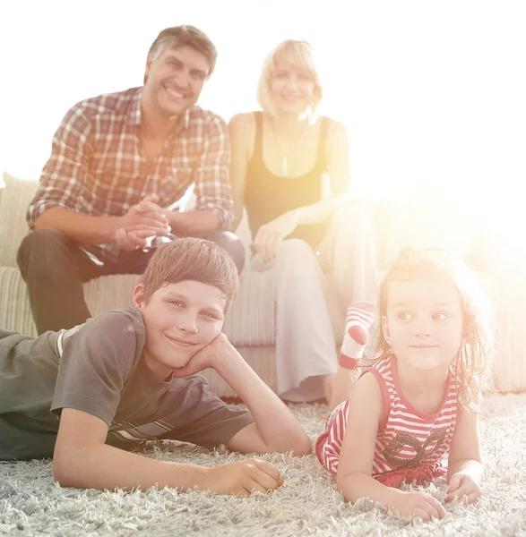 Portret van kinderen terwijl de ouders zitten op de Bank in levende roo — Stockfoto