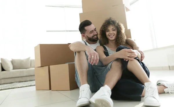 Подружня пара сидить біля картонних коробок в новій квартирі — стокове фото