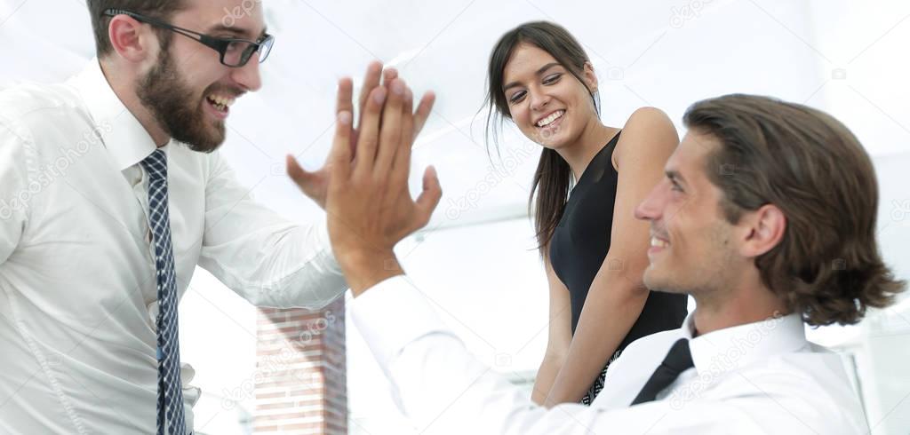 business colleagues giving each other high five.
