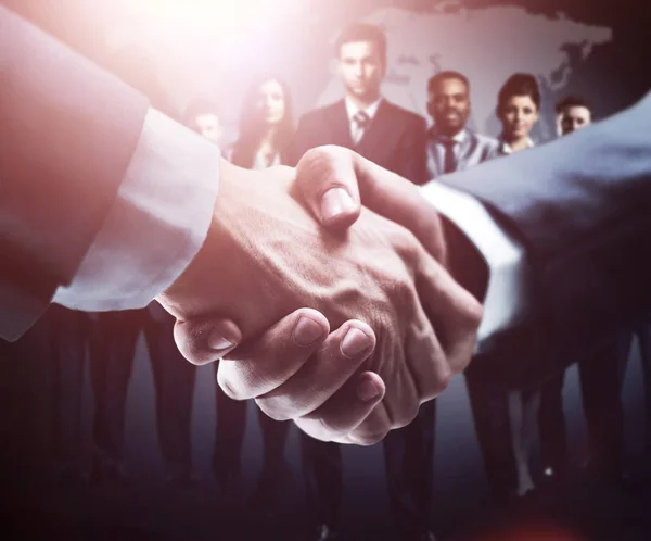 Handskakningen på gruppen bakgrund av affärsmän i mörka färger — Stockfoto