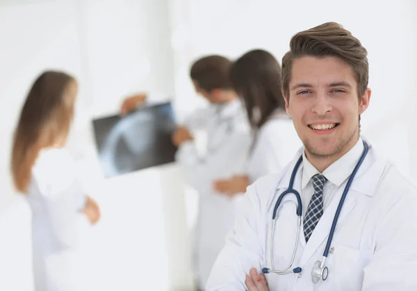 Junge Ärztin über den Hintergrund von Kollegen — Stockfoto