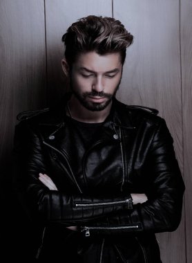 Ahşap duvara yaslanmış yakışıklı bir adamın portresi..