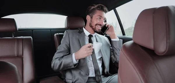 Jovem empresário tomando um café em seu carro — Fotografia de Stock