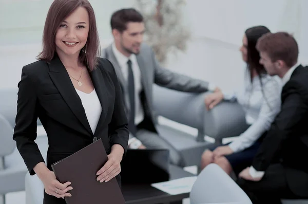 Succesvolle zakenvrouw staat met haar personeel op de achtergrond — Stockfoto