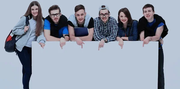 Full length portrait of confident college students displaying blank billboard against white background — Stock Photo, Image