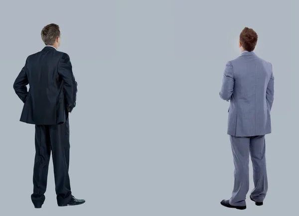 Dois homens de negócios de trás olhando para algo sobre um fundo branco — Fotografia de Stock