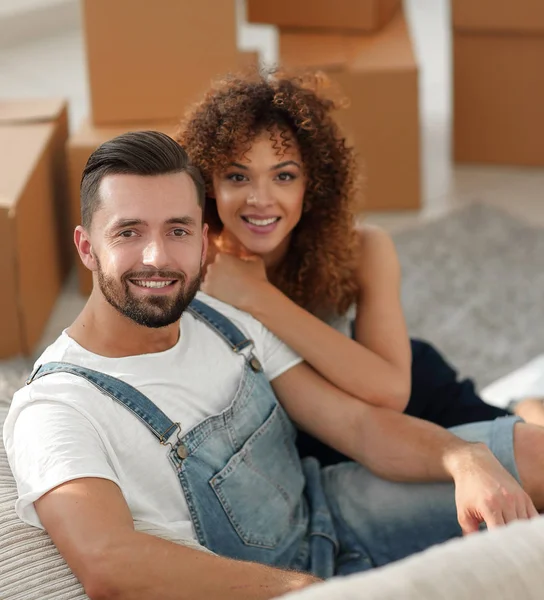 Jovem casal sentado no chão em um novo apartamento — Fotografia de Stock