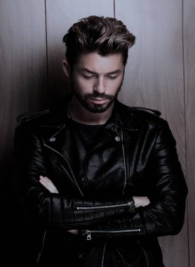 Ahşap duvara yaslanmış yakışıklı bir adamın portresi..