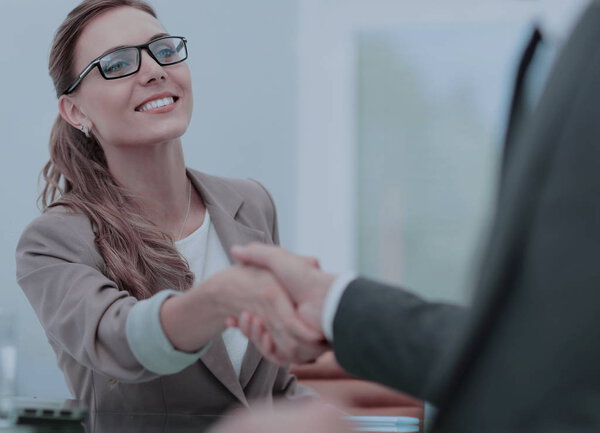 Счастливые деловые партнеры пожимают друг другу руки в офисе
