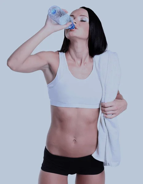Happy smiling woman in sportswear drinking water, isolated over white background — Stock Photo, Image
