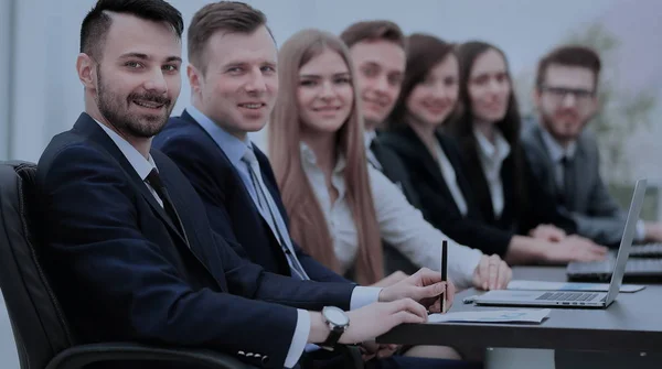 Hombre de negocios confiado mirando a la cámara entre colegas — Foto de Stock