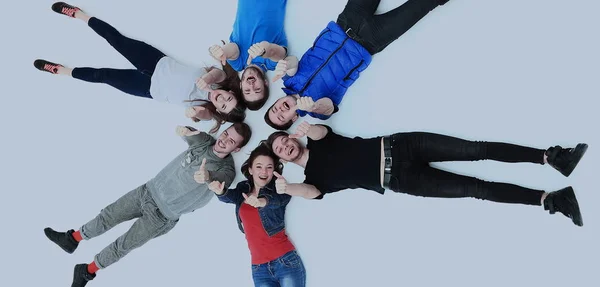 Junge Leute legen sich hin, gestikulieren mit dem Daumen nach oben — Stockfoto