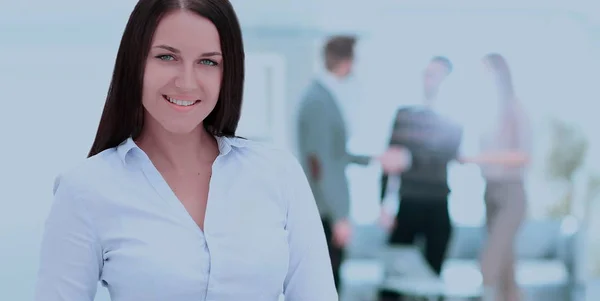 Úspěšná obchodní žena stojící se svými zaměstnanci v pozadí — Stock fotografie