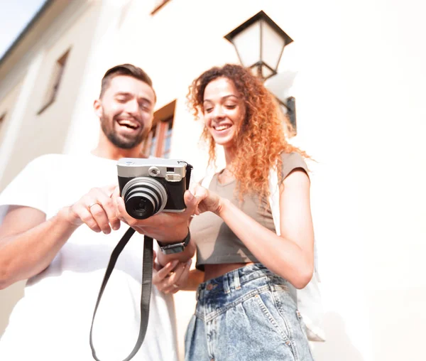 Retrato de jovens amigos andando olhando para as fotos — Fotografia de Stock