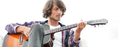 Yakışıklı adam evde kanepede gitar çalmaya