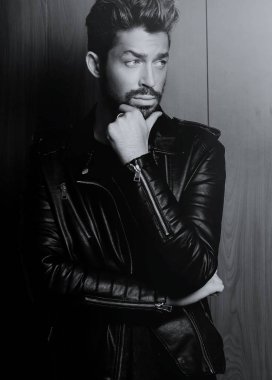 Ahşap duvara yaslanmış yakışıklı bir adamın portresi..