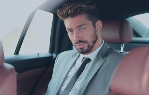 Retrato de un hombre de negocios guapo en su coche — Foto de Stock