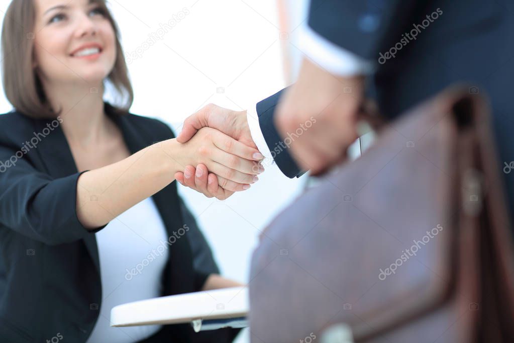 Two handsome men shaking hands with smile while sitting
