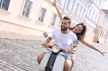 mutlu genç bir çift bir scooter üzerinde eğleniyor