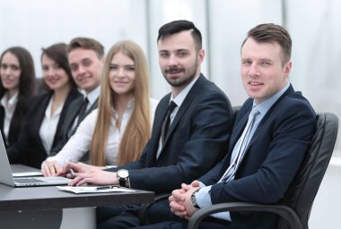 İş ekibi konferans odasındaki masada oturuyor.