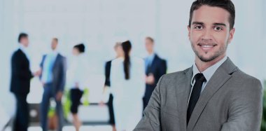 ofisinde memnuniyeti ile kameraya bakarak mutlu olgun iş adamı