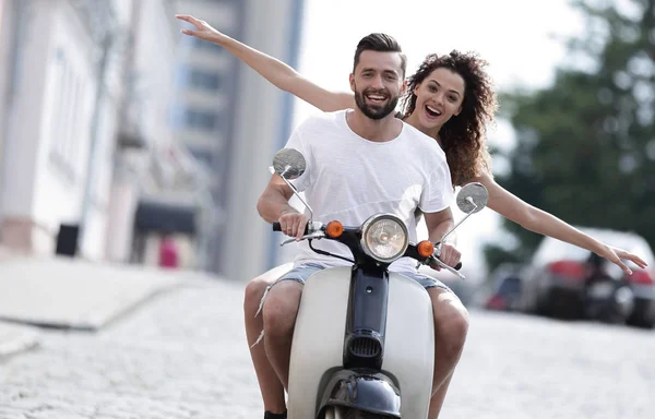 Feliz joven pareja montando un scooter en la ciudad en un día soleado —  Fotos de Stock