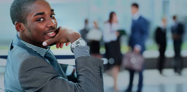 Retrato del hombre de negocios afroamericano sonriente con ejecutivos trabajando en segundo plano —  Fotos de Stock