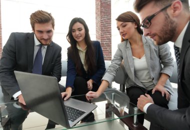 Yoğun iş adamları bir konferans sırasında bir dizüstü bilgisayarı kullanıyor