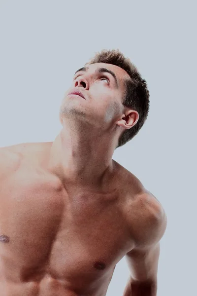 Porträt eines muskulösen Mannes, der vor weißem Hintergrund posiert — Stockfoto