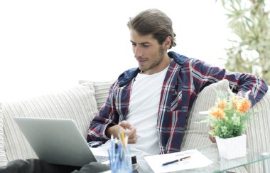 şaşırmış genç adam evden dizüstü bilgisayar ile çalışma.