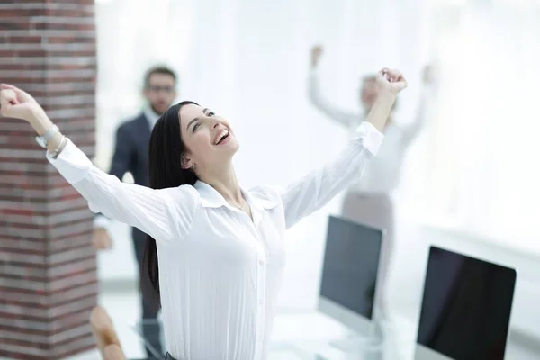 Feliz joven mujer de negocios en un fondo borroso oficina . — Foto de Stock