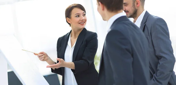 Mujer de negocios mostrando información de un equipo de negocios en el rotafolio — Foto de Stock