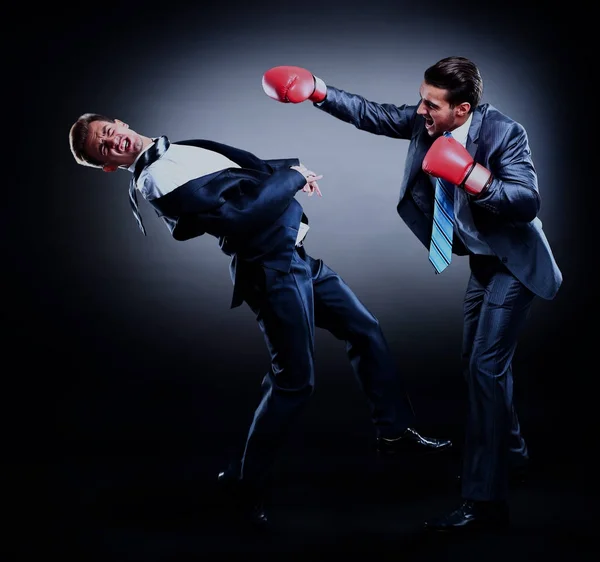 Dos jóvenes empresarios boxeando contra fondo oscuro . — Foto de Stock