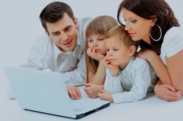 Amare la famiglia guardando un computer portatile sdraiato sul letto a casa . — Foto Stock