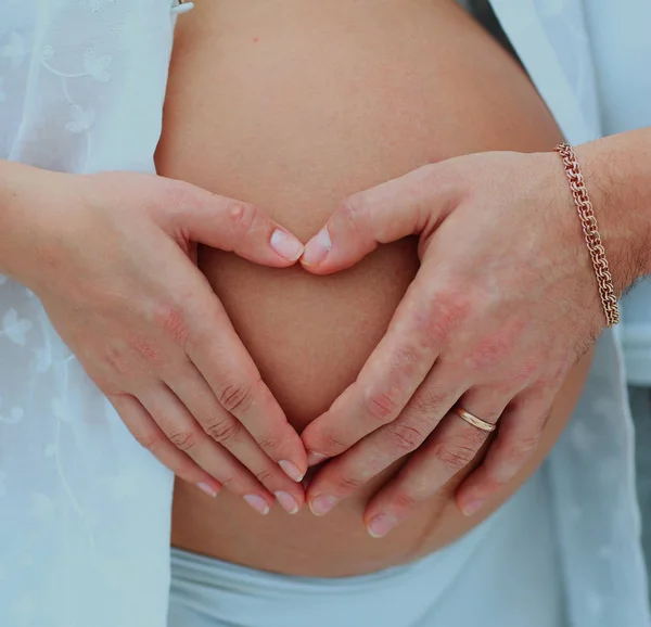 Close-up image of the heart by moms and dads handson her baby bump. — Stock Photo, Image