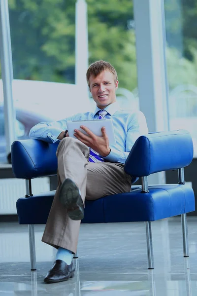 Zakenman met zijn tablet op kantoor. — Stockfoto