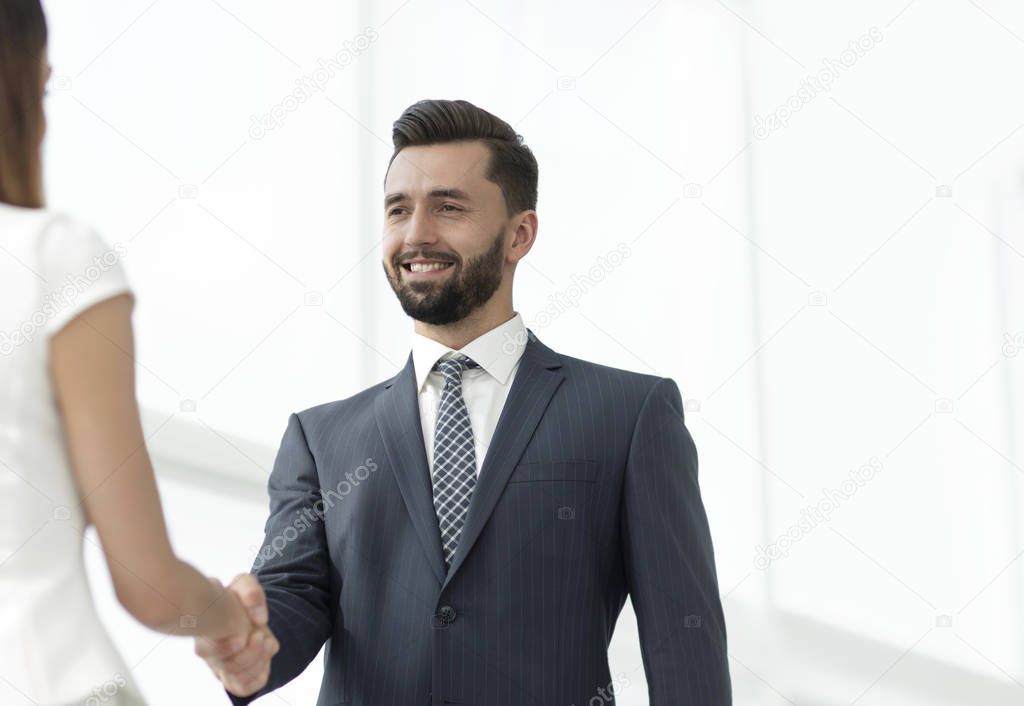 An attractive business man and woman team shaking hands