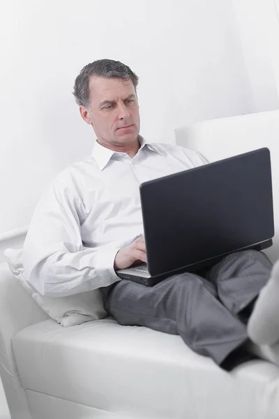 Businessman working on laptop while sitting in a hotel room — Stock Photo, Image